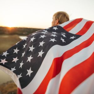 Young Man Holding An American Flag At Sunset